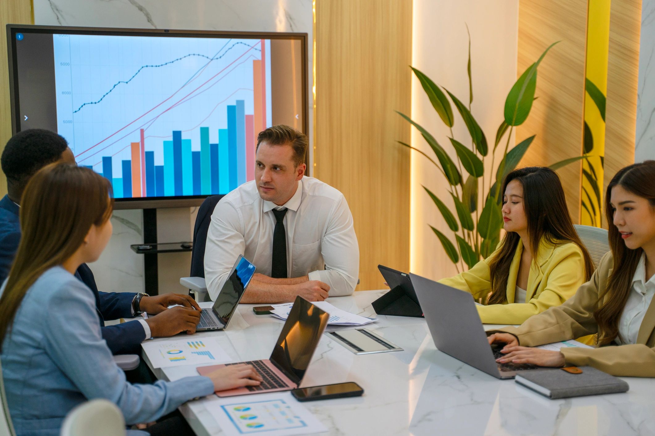Marketing team meeting around a laptop in a conference room